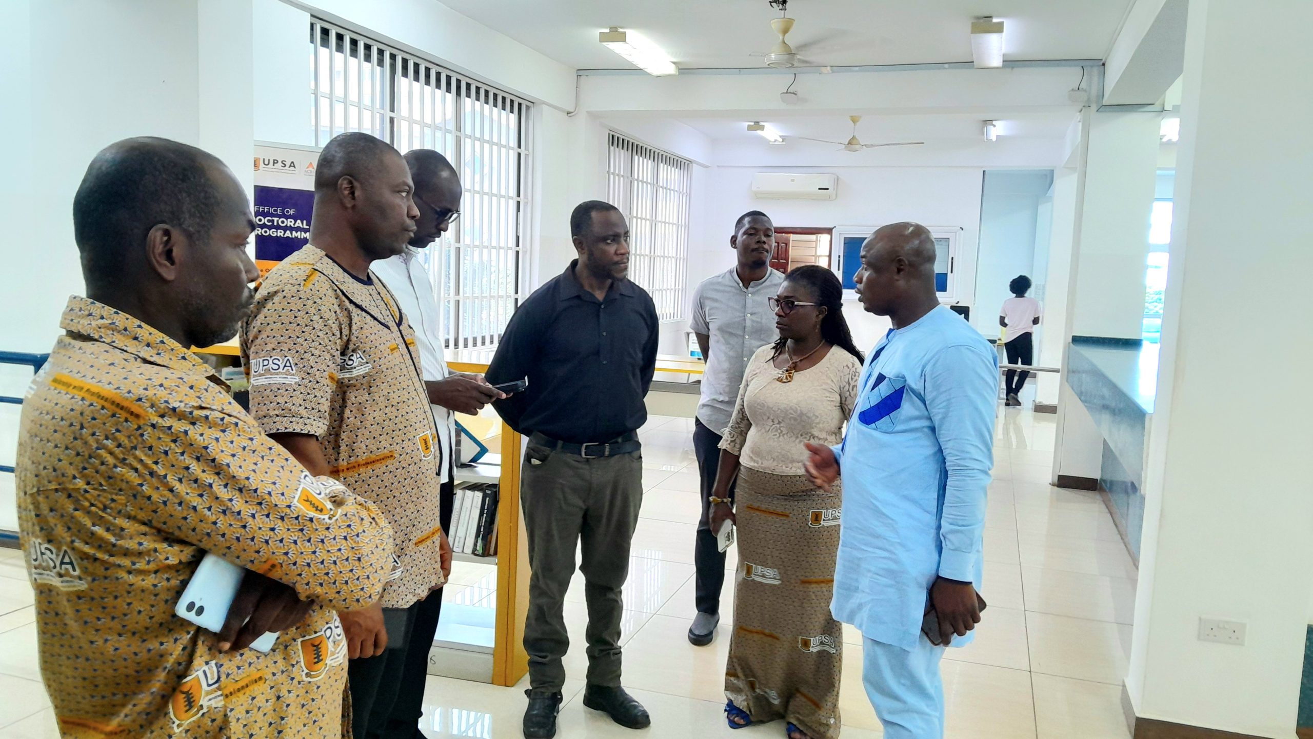 A group of people having a discussion in the Joshua Alabi library.